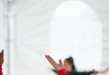 간단한 스트레칭으로 몸 풀기 woman in red long sleeve shirt raising her hands