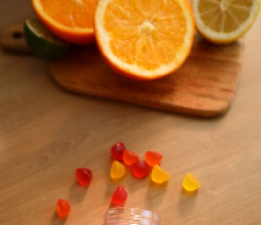 겨울철 비타민 D 결핍 해결법 a bottle of gummy vitamins sitting on top of a wooden table